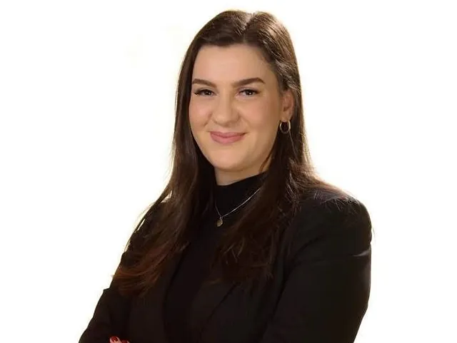 Kvinne med brunt hår og svart bluse